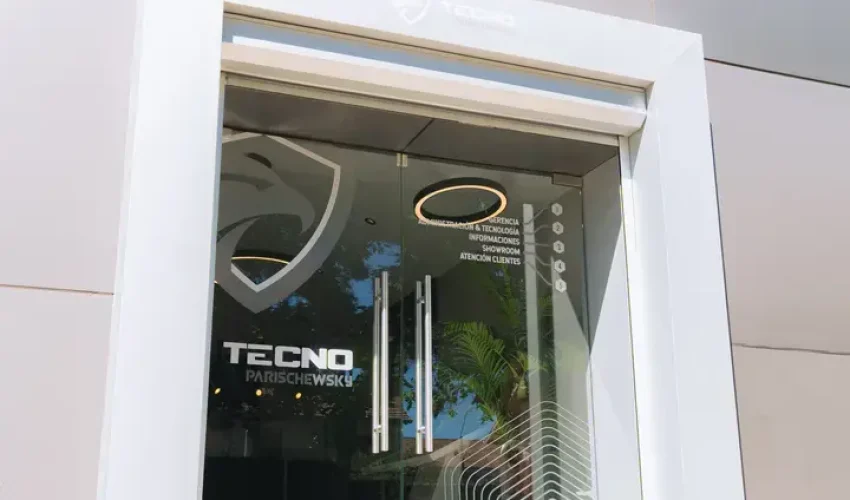 Entrada principal de sucursal Tecnowsky en Los Ángeles con logo en vidrio, empresa de seguridad y tecnología